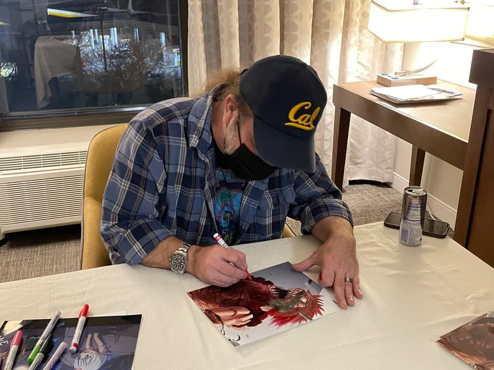 A man signing a print at a private signing